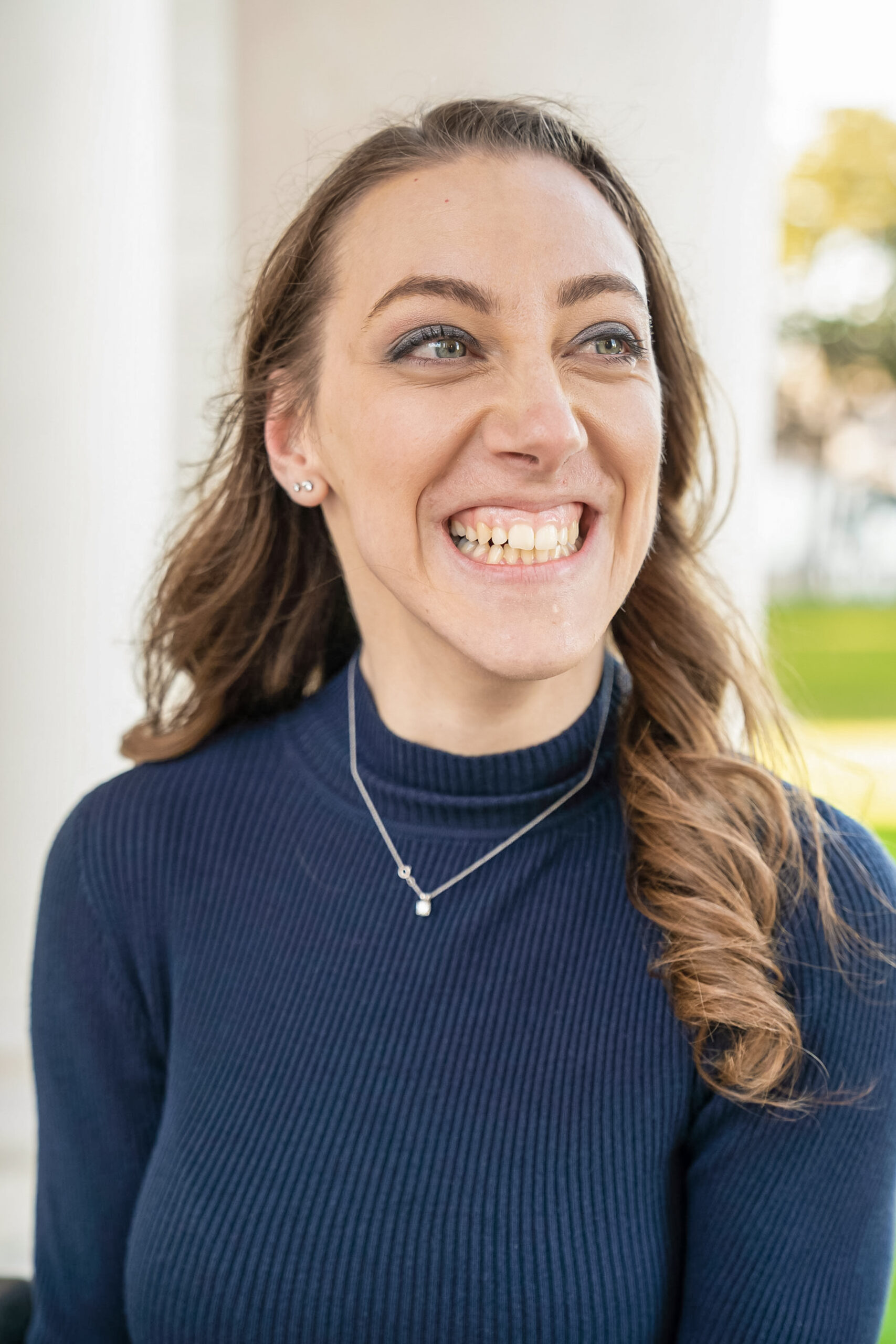 Head and shoulders photo of Alva Gardner.  Alva has long light borwn hair, blue eys, a big smile, and is wearing a blue ribbed mock turtleneck with a single pearl necklace on a silver chain.